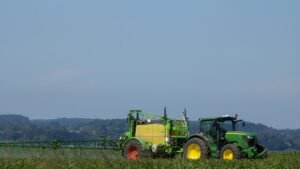 Tracteur pulverisant un produit sur un champ agricole