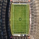 Calendrier Ligue 1 2026-2027 : pelouse et tribunes d'un stade de football vues du ciel