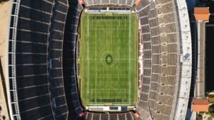 Calendrier Ligue 1 2026-2027 : pelouse et tribunes d'un stade de football vues du ciel