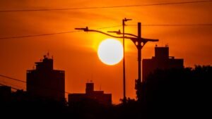 Canicule : soleil brûlant sur un ciel rouge au-dessus des toits