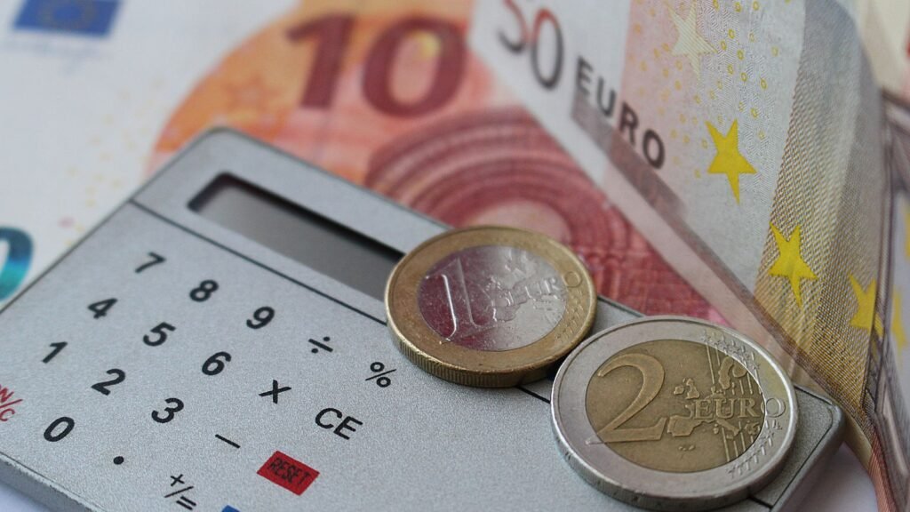 Pieces de monnaie et calculatrice, illustration economie et finances