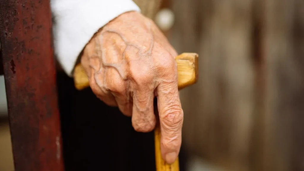 Personne âgée s'appuyant sur une canne pour illustrer l'assurance dépendance et la rente autonomie